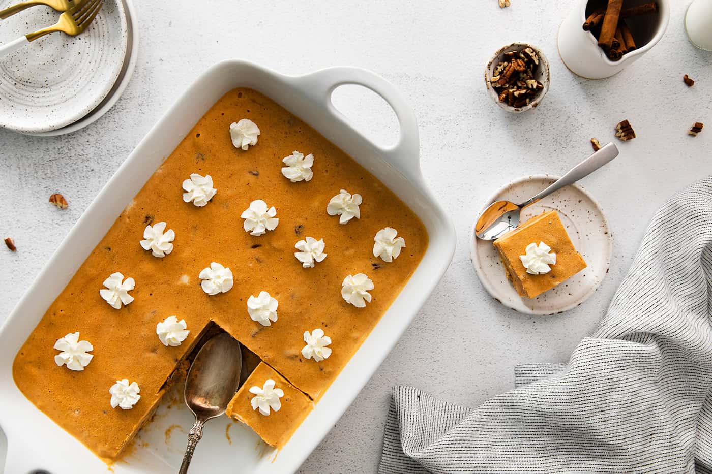 a white pan of frozen pumpkin icebox cake, with an individual piece on a plate