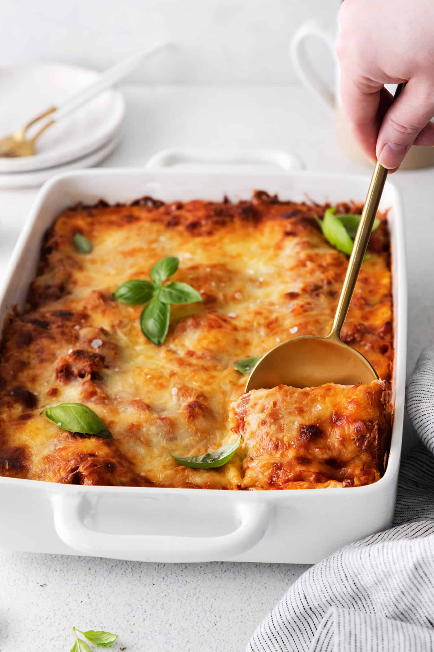 A spoon digging into homemade lasagna