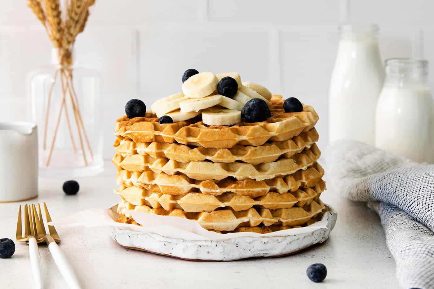 A stack of homemade waffles topped with blueberries and bananas