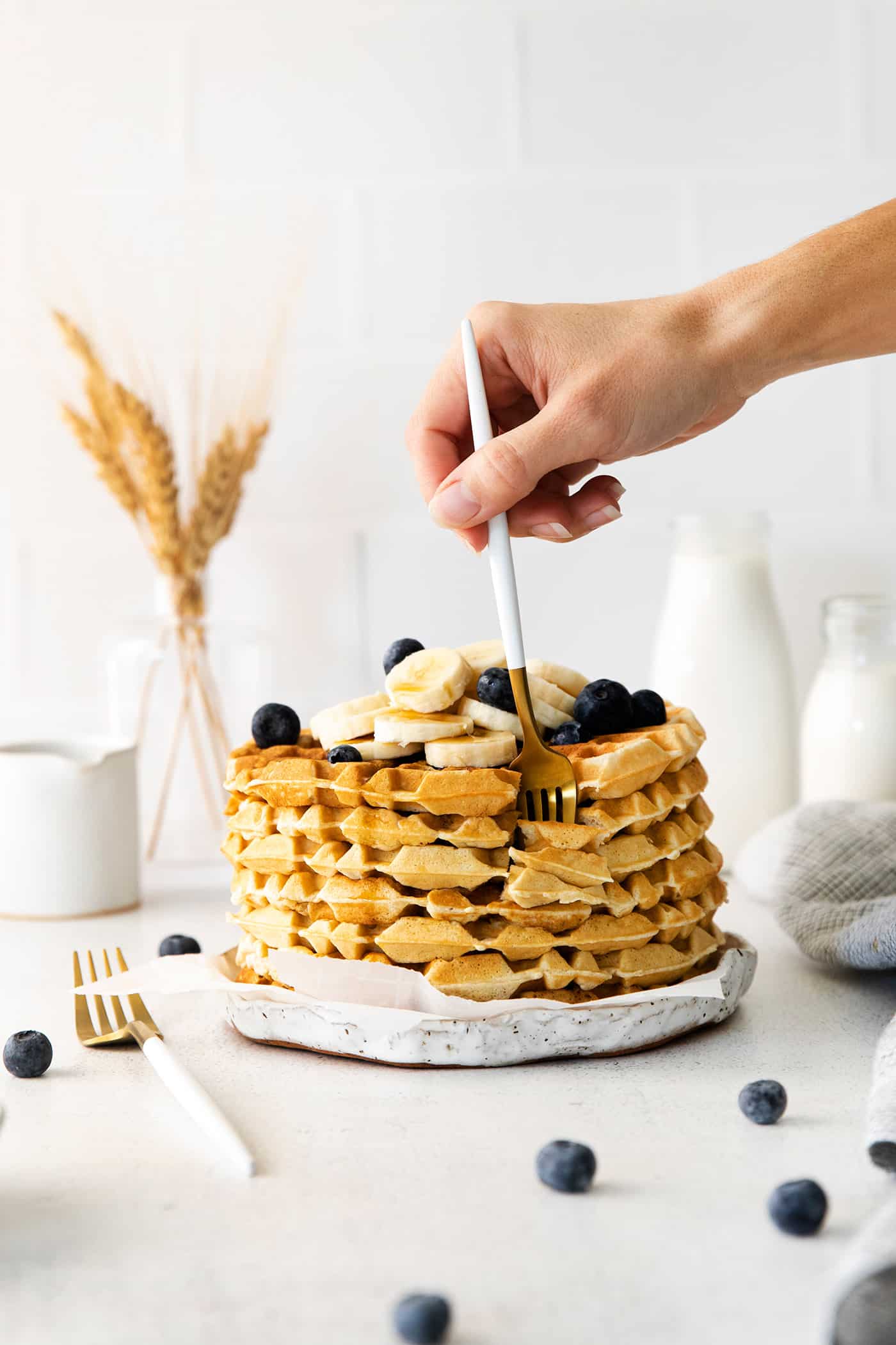 A fork digging into a stack of waffles