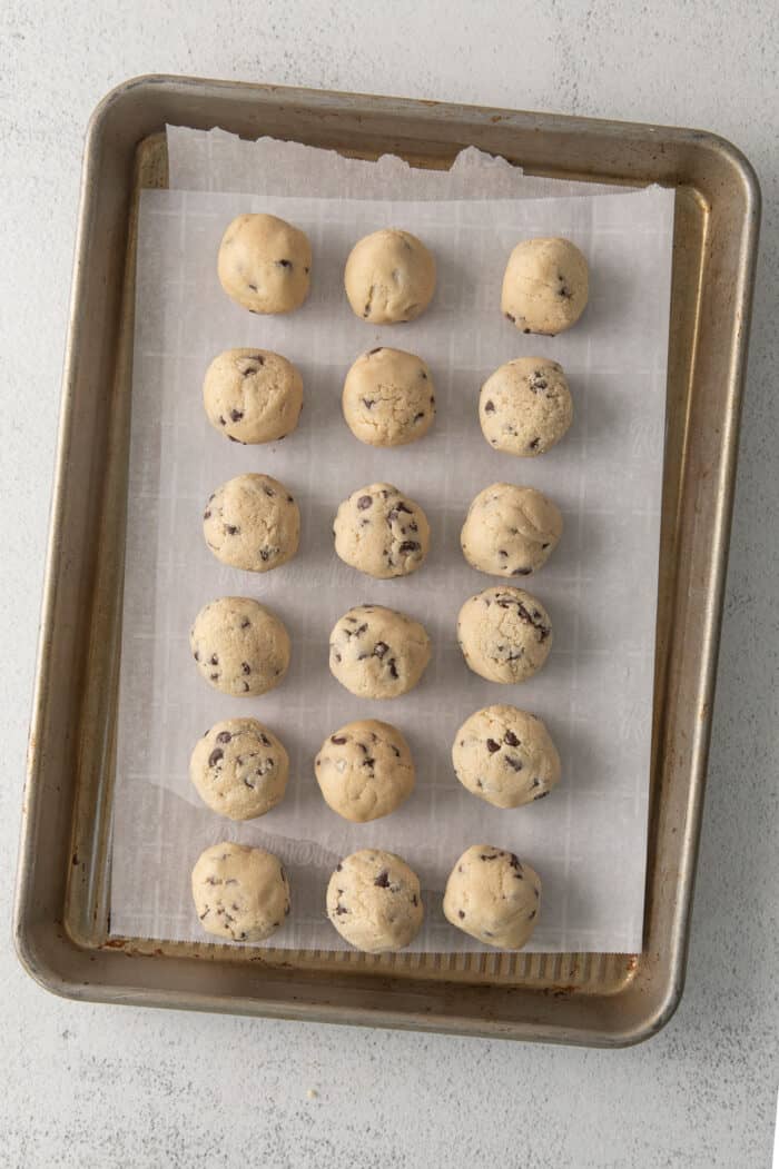 Balls of edible cookie dough on a baking sheet