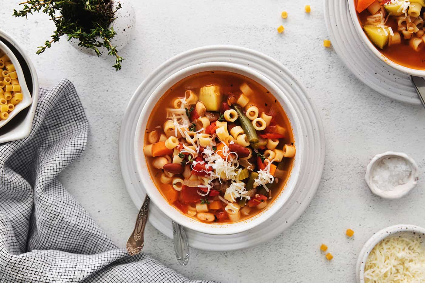 Overhead view of a bowl of minestrone soup topped with parmesan