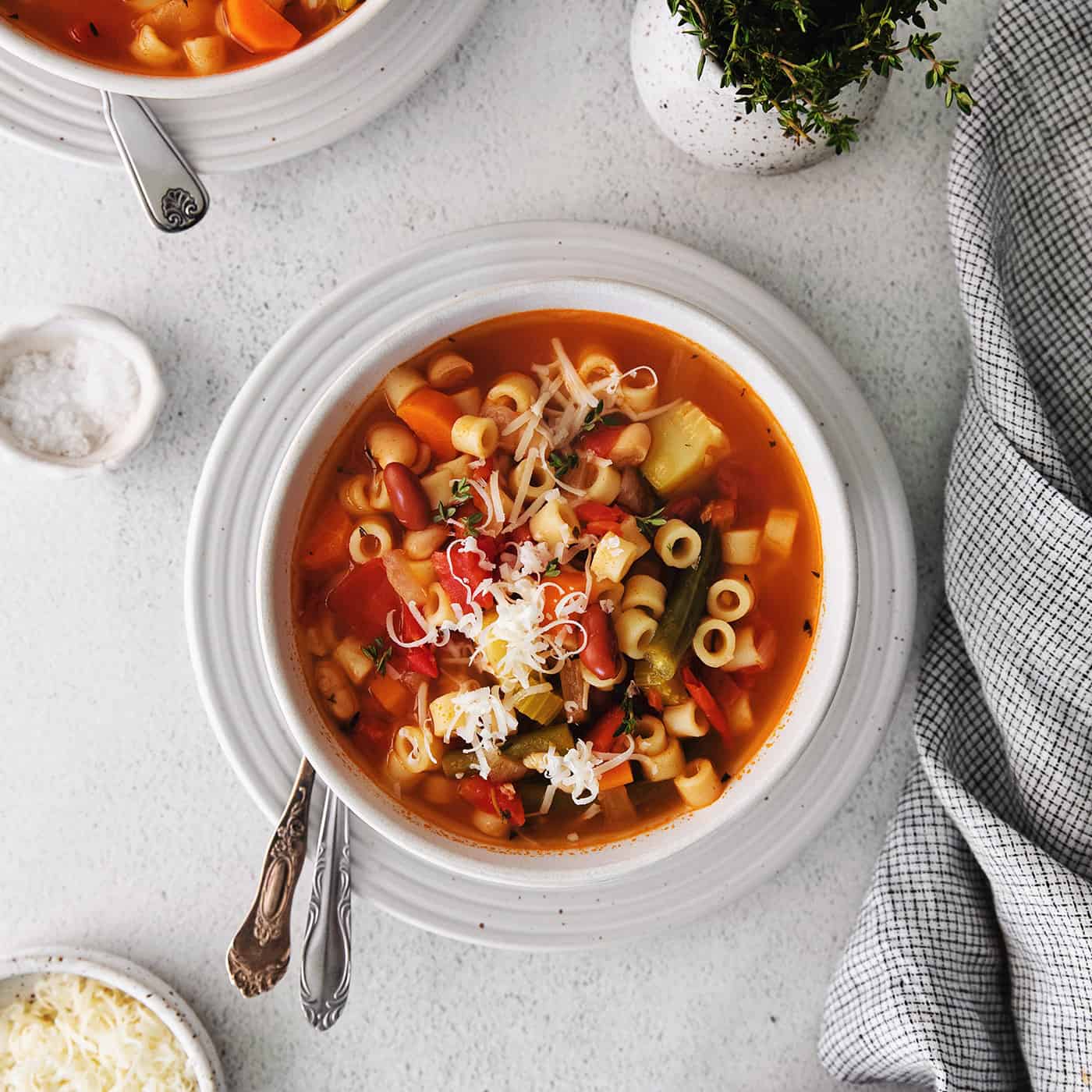 Overhead view of a bowl of minestrone soup topped with parmesan