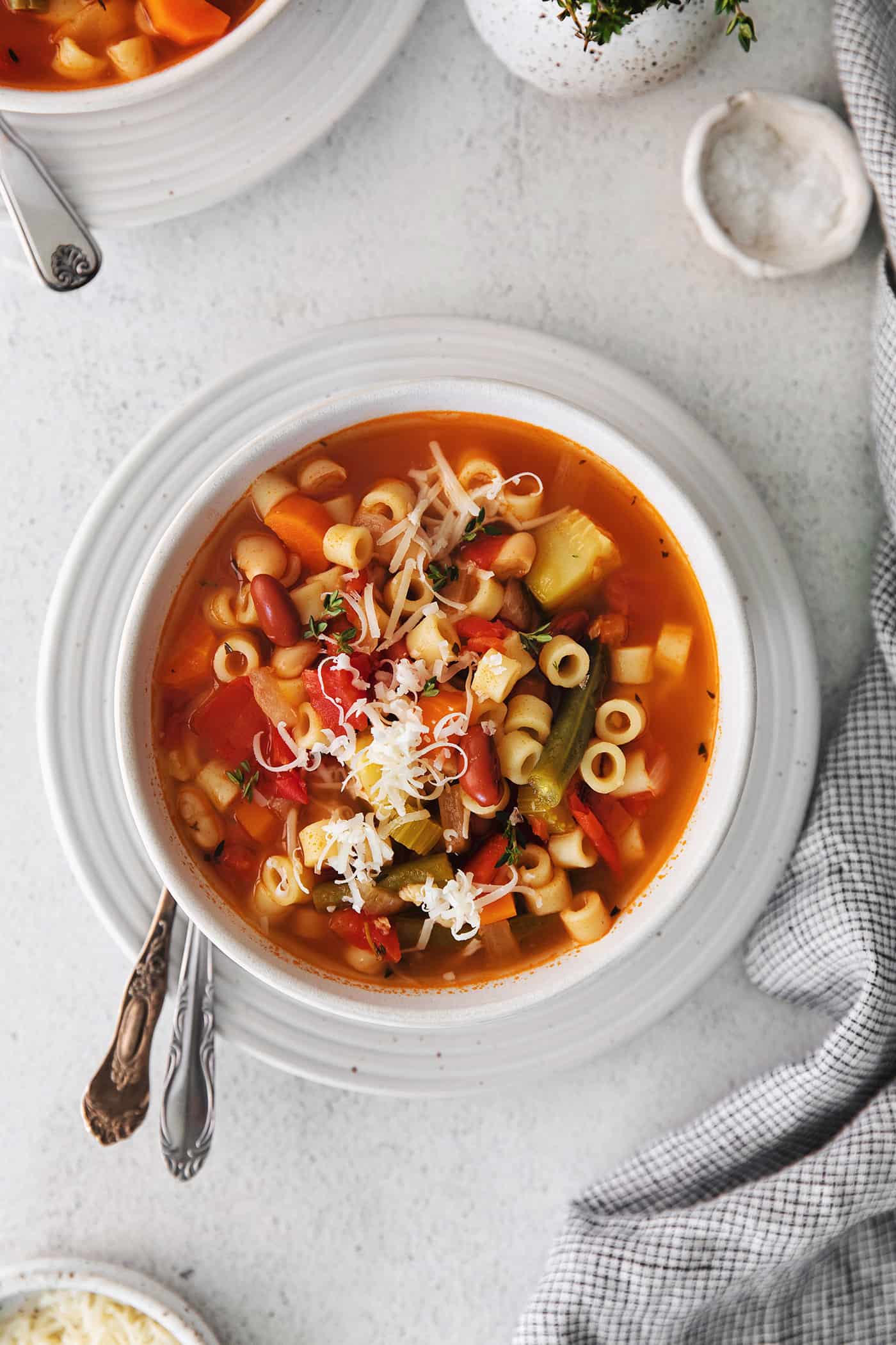 Overhead view of a bowl of minestrone soup topped with parmesan