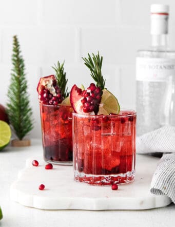 Two pomegranate gin and tonics with rosemary