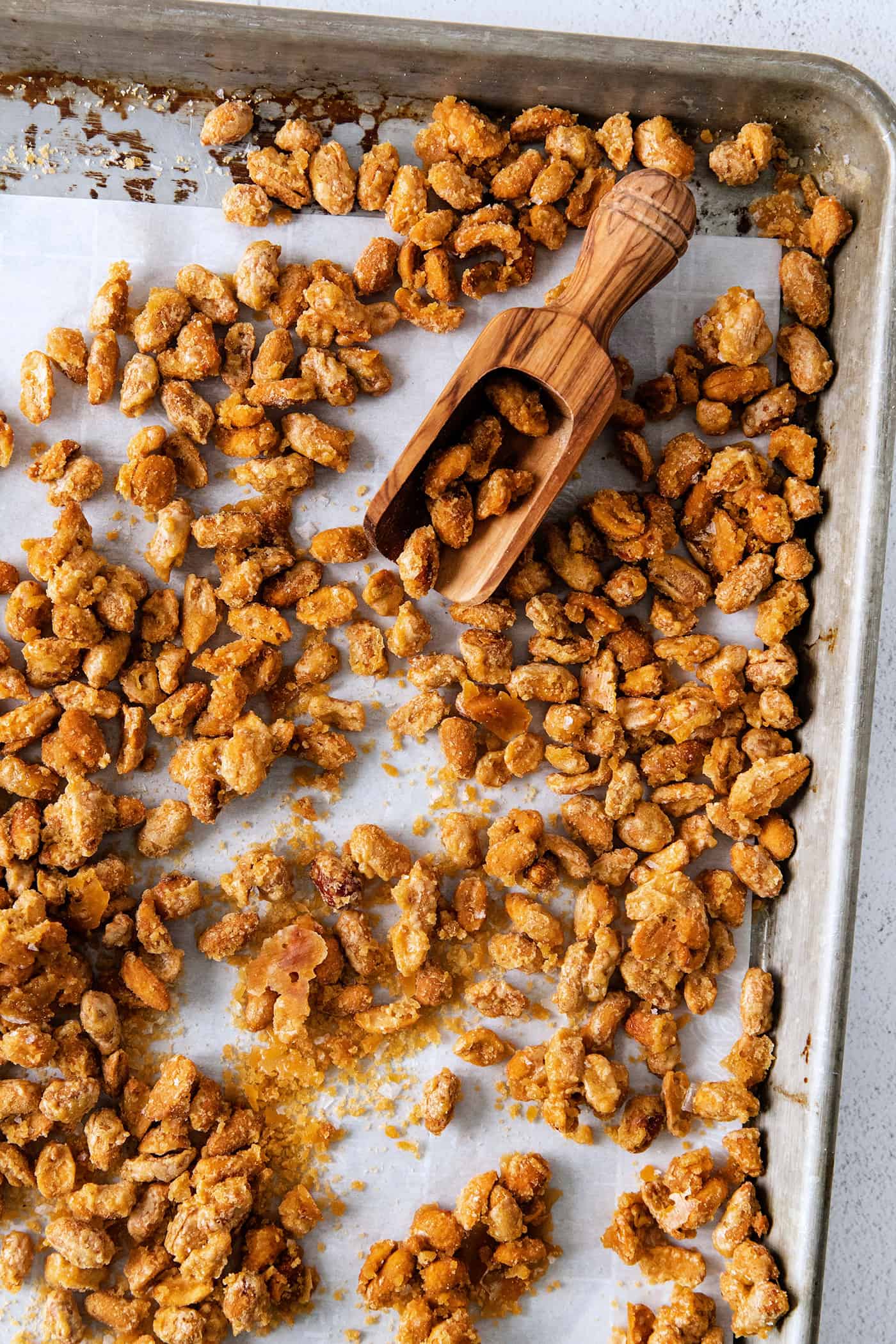 A scoop on a baking sheet of beer nuts