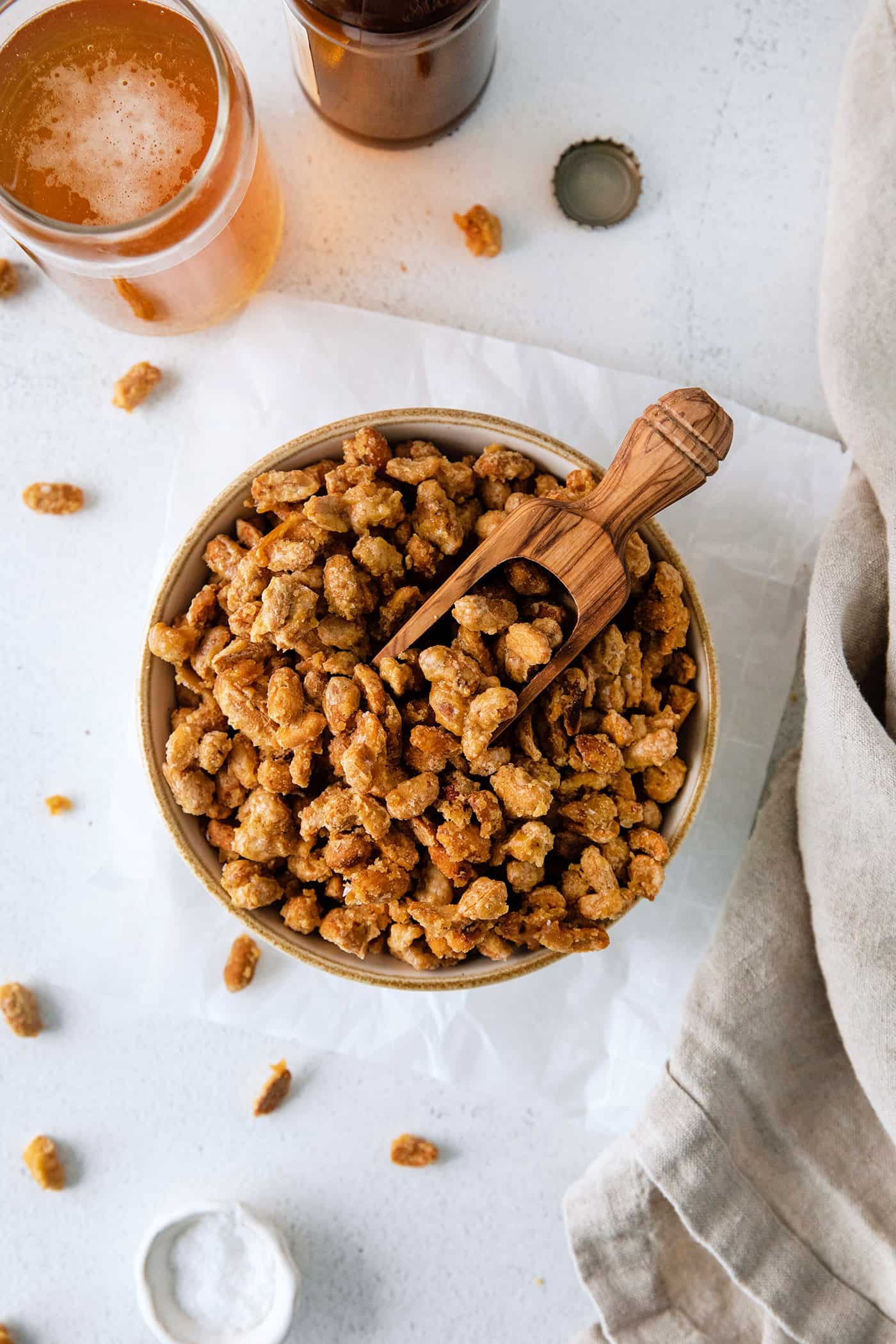 A bowl of beer nuts with a wooden spoon