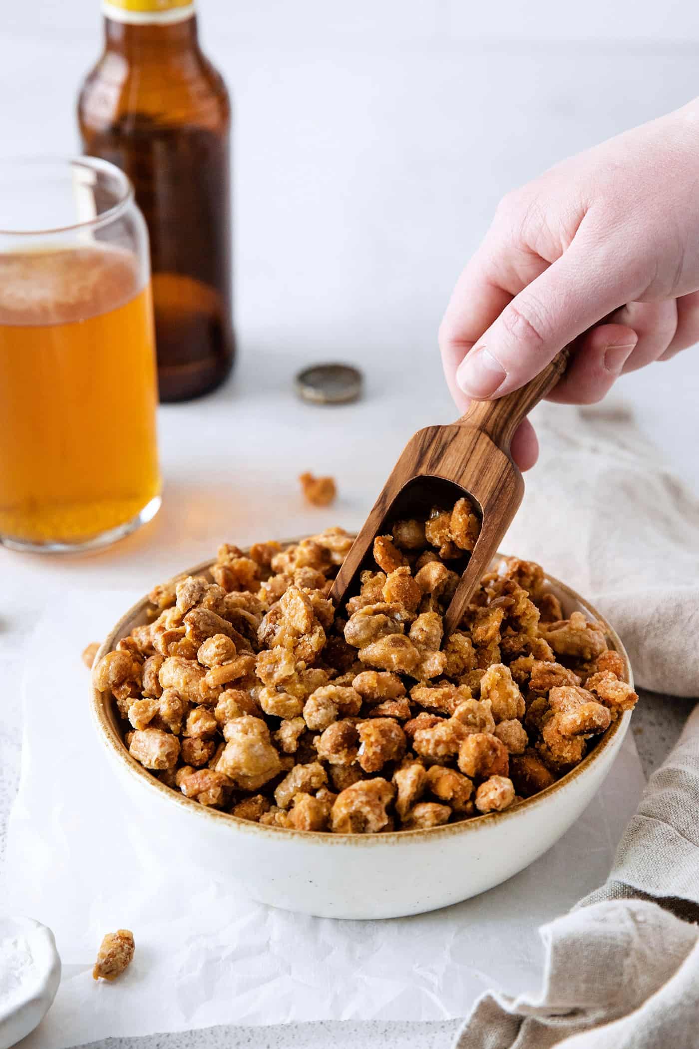 A wooden scoop in a bowl of beer nuts