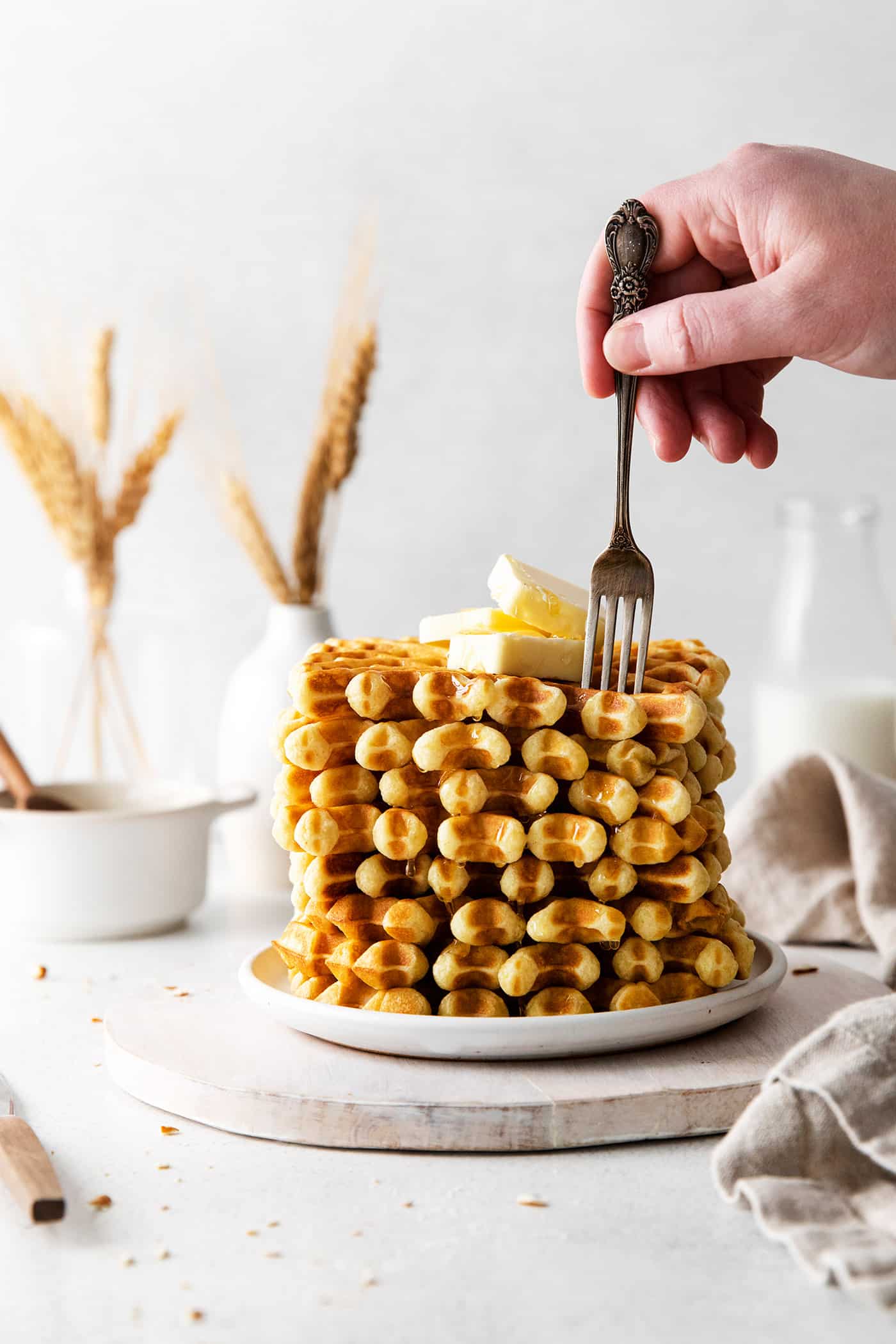 A fork digging into buttermilk waffles