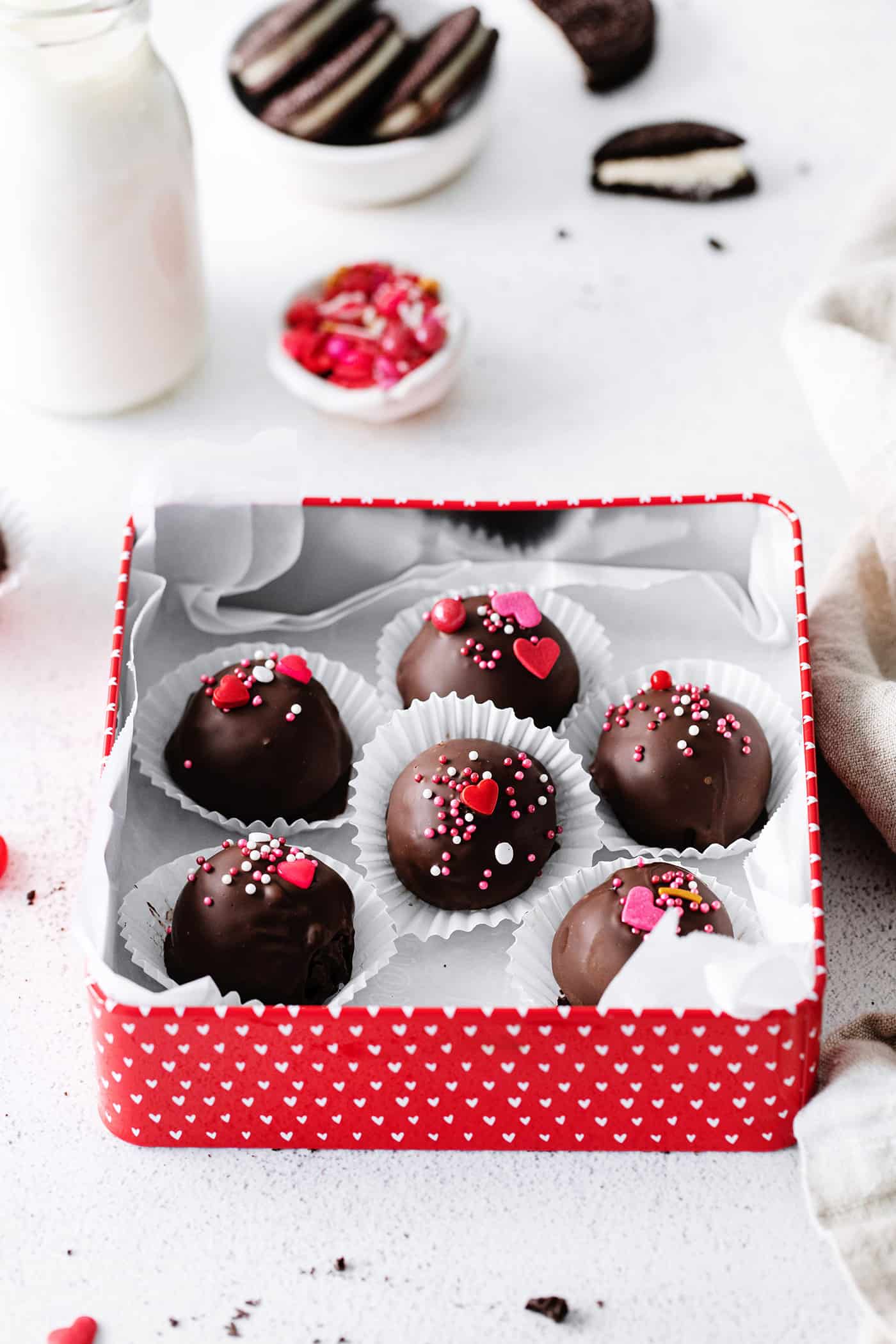 Oreo truffles with sprinkles in a square red box