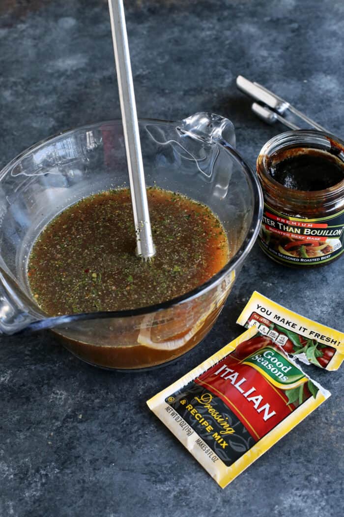 Italian seasoning and broth in a mixing bowl