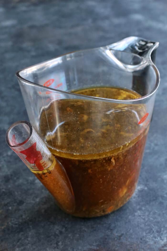 Italian beef au jus in a measuring cup