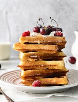 A stack of Belgian waffles topped with cherries