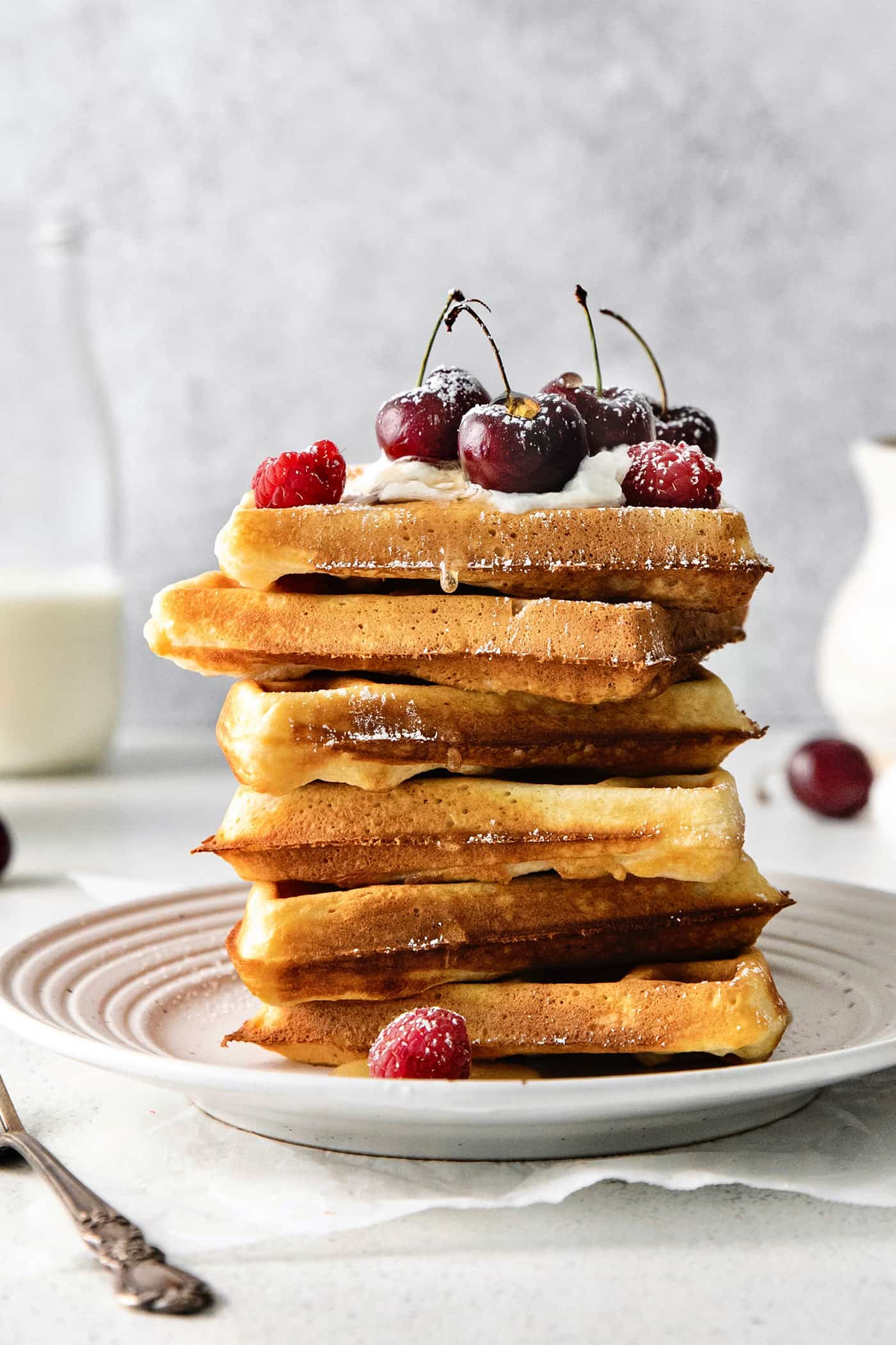 A stack of Belgian waffles topped with cherries
