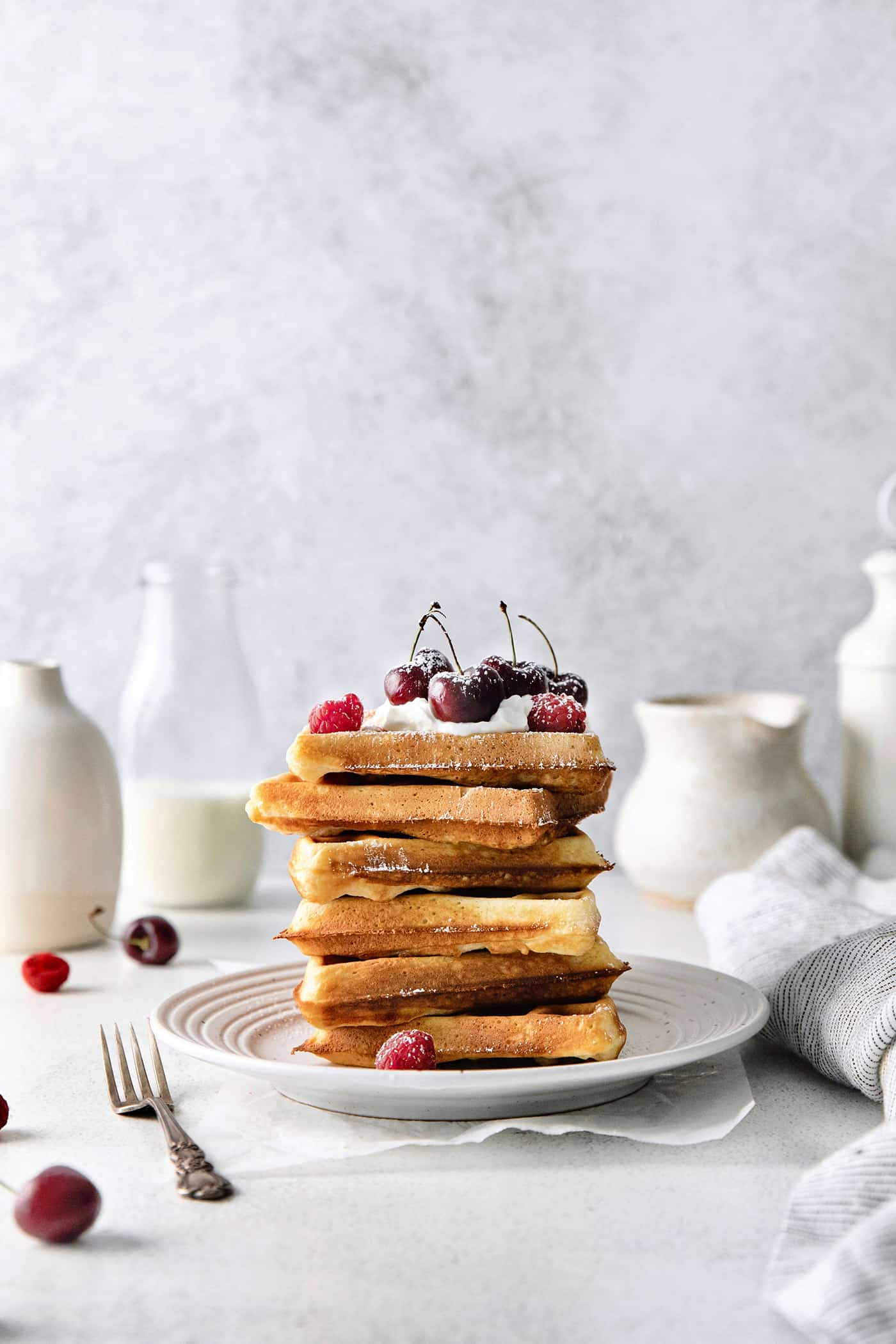 A stack of homemade waffles on a white plate