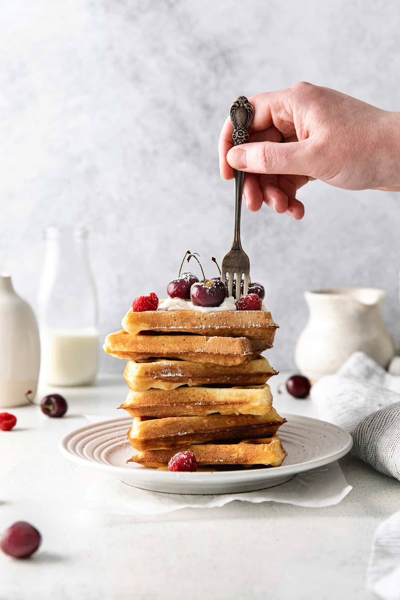 A fork in the top of a stack of homemade belgian waffles