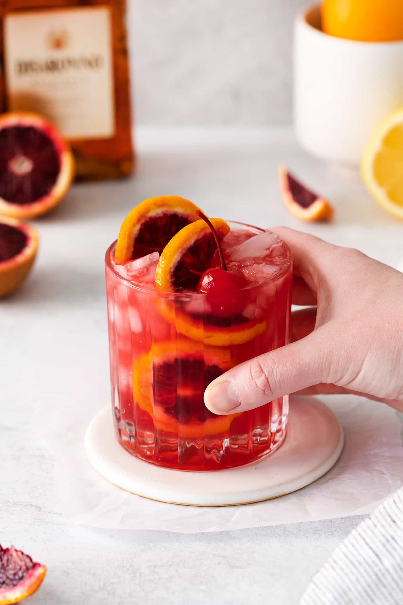 a hand holding a blood orange cocktail