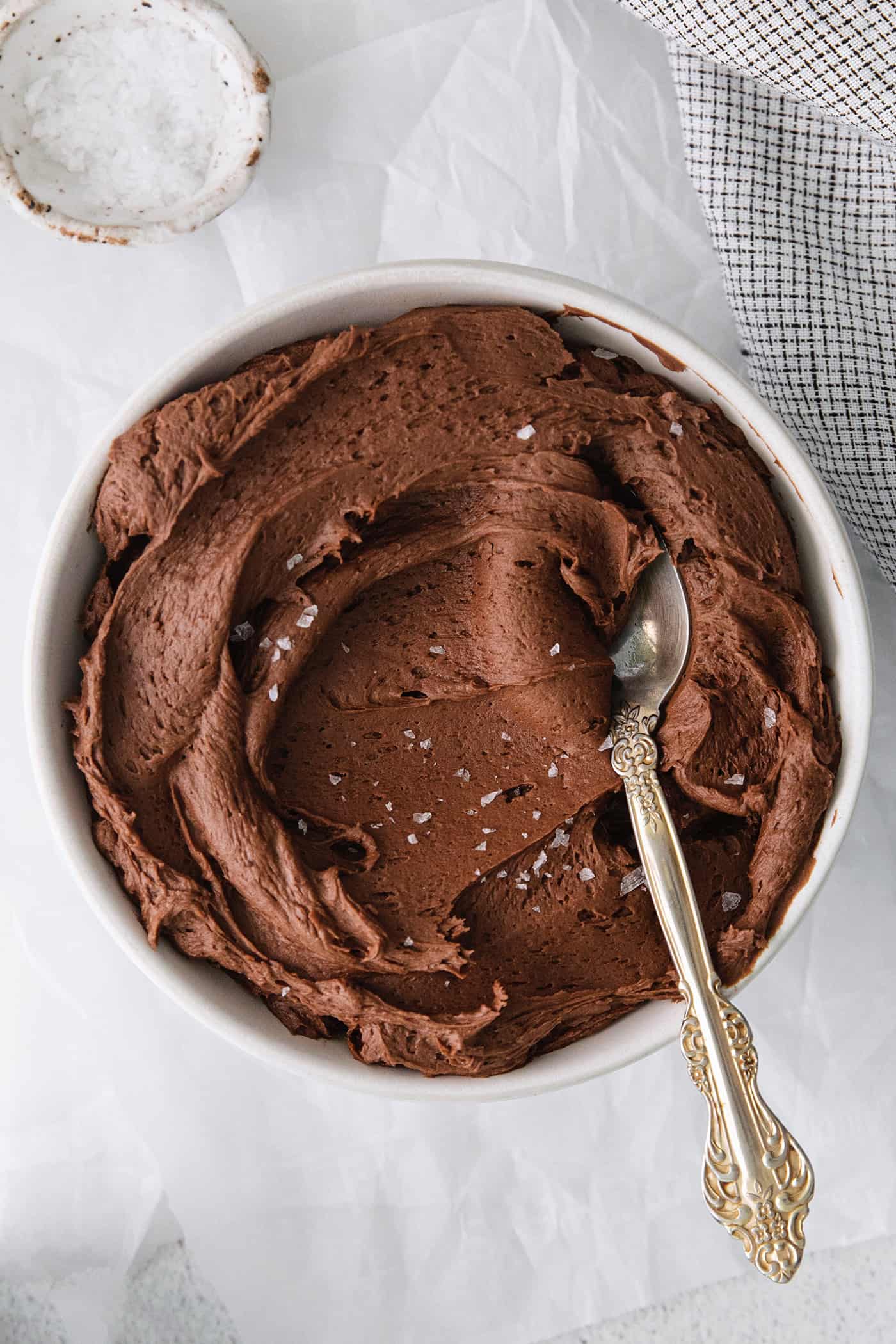 A spoon stirring chocolate buttercream