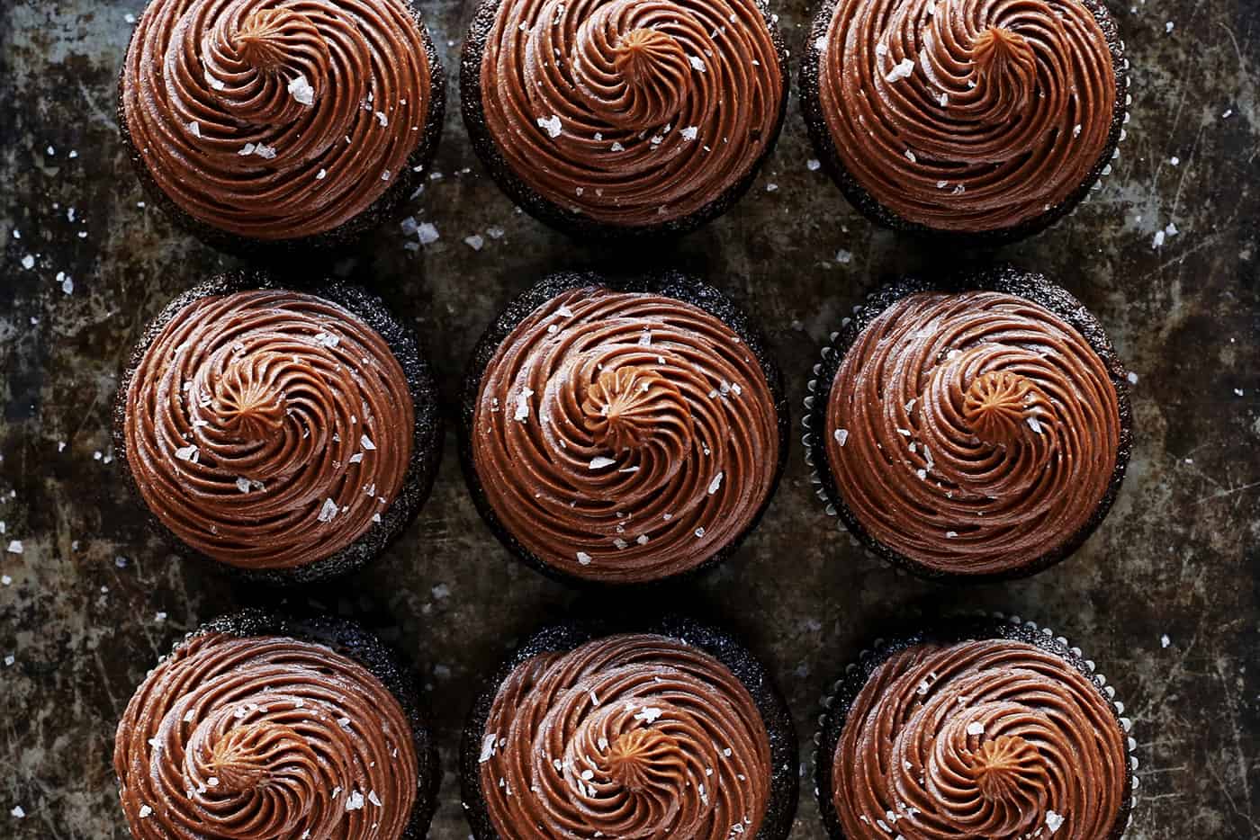 Overhead view of chocolate cupcakes topped with chocolate buttercream