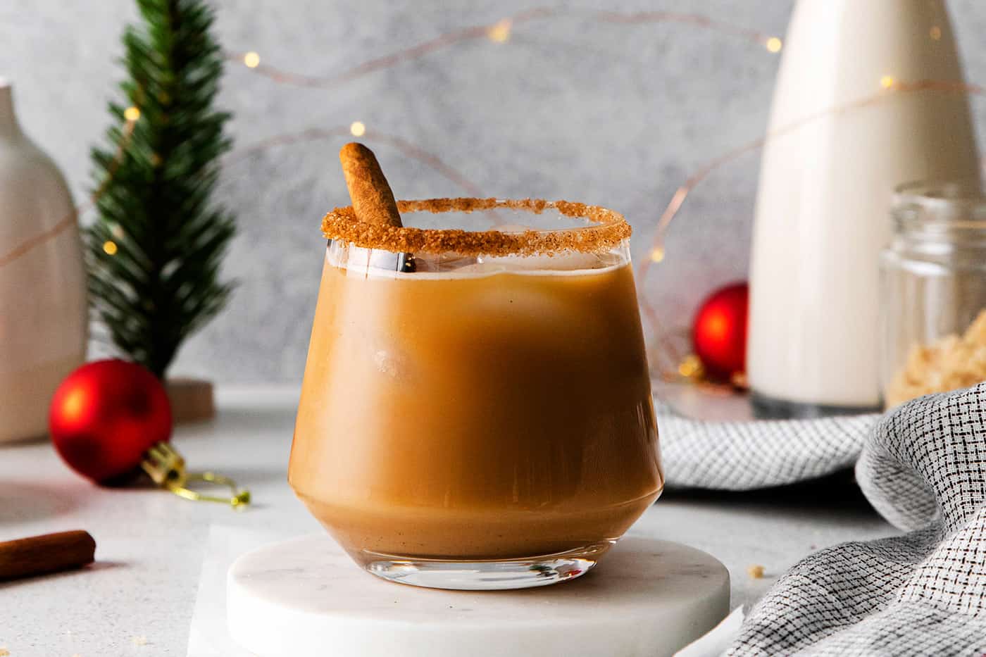 a cinnamon spiced eggnog white Russian cocktail with festive Christmas decorations