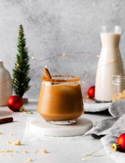 a white Russian cocktail with eggnog and cinnamon syrup, plus Christmas decorations