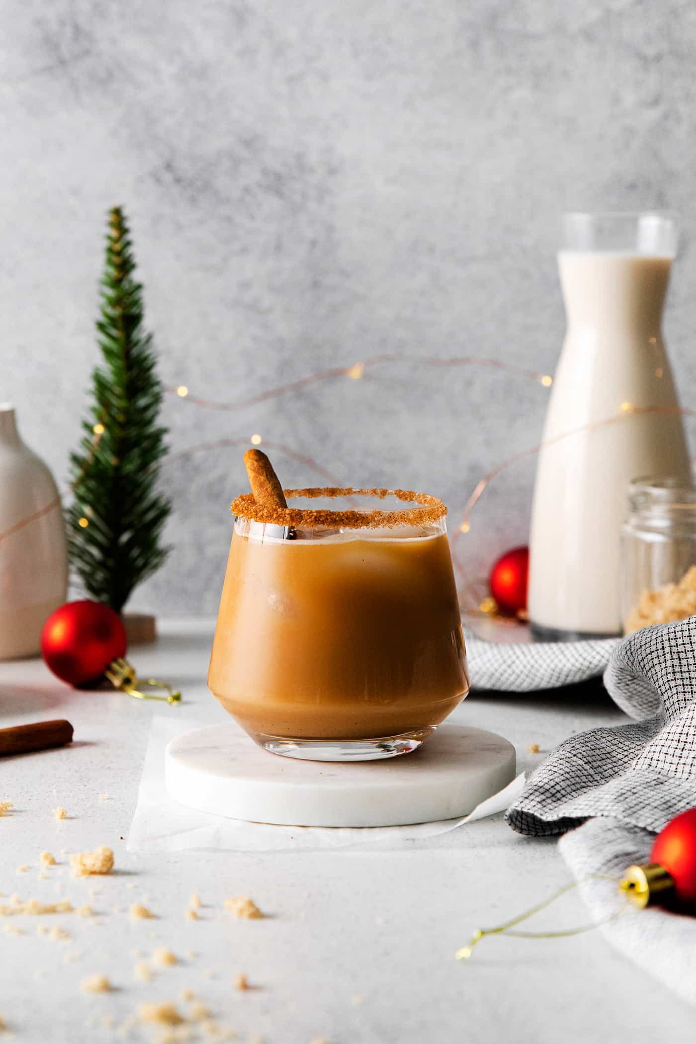 a white Russian cocktail with eggnog and cinnamon syrup, plus Christmas decorations