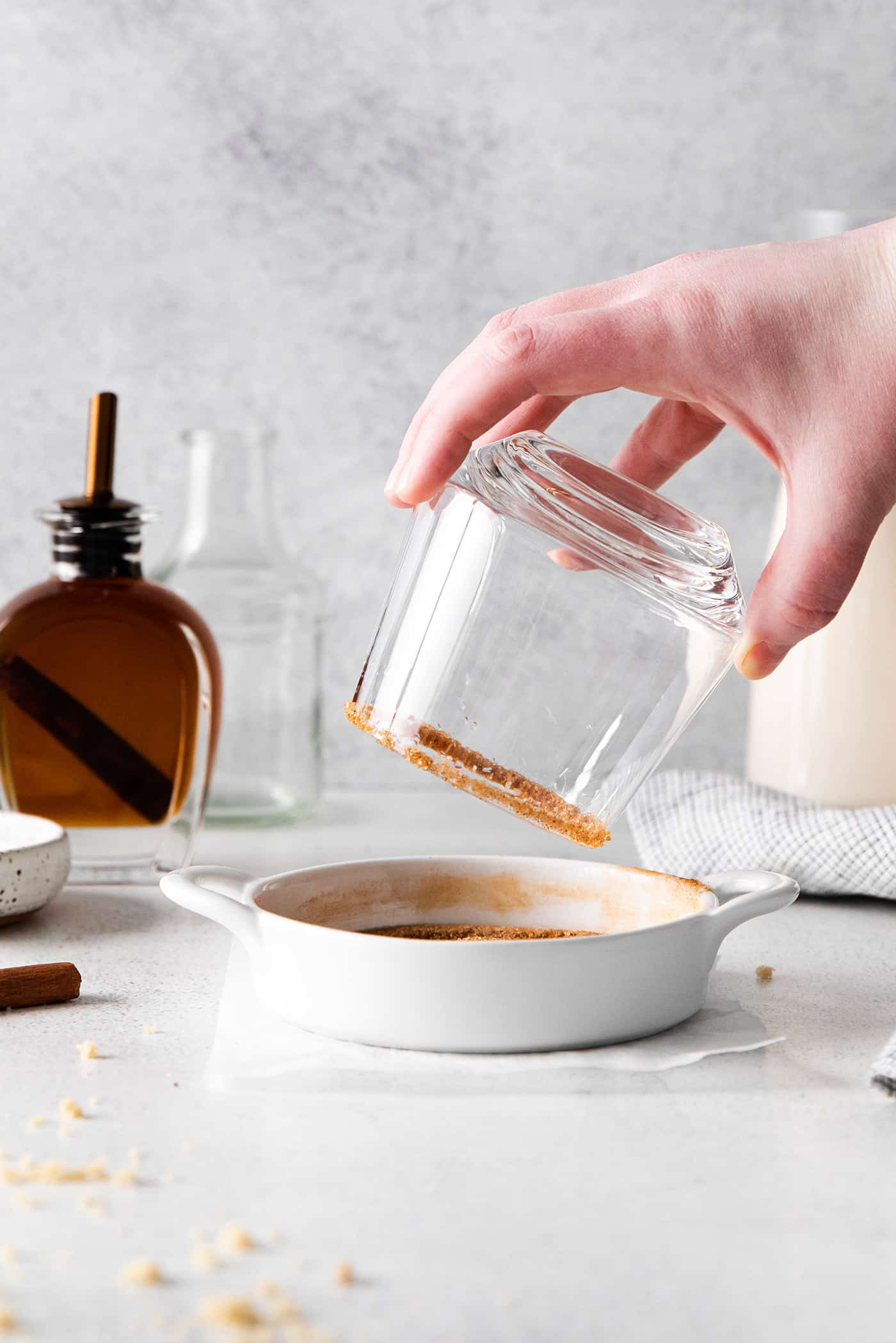 dipping the rim of a glass into cinnamon sugar