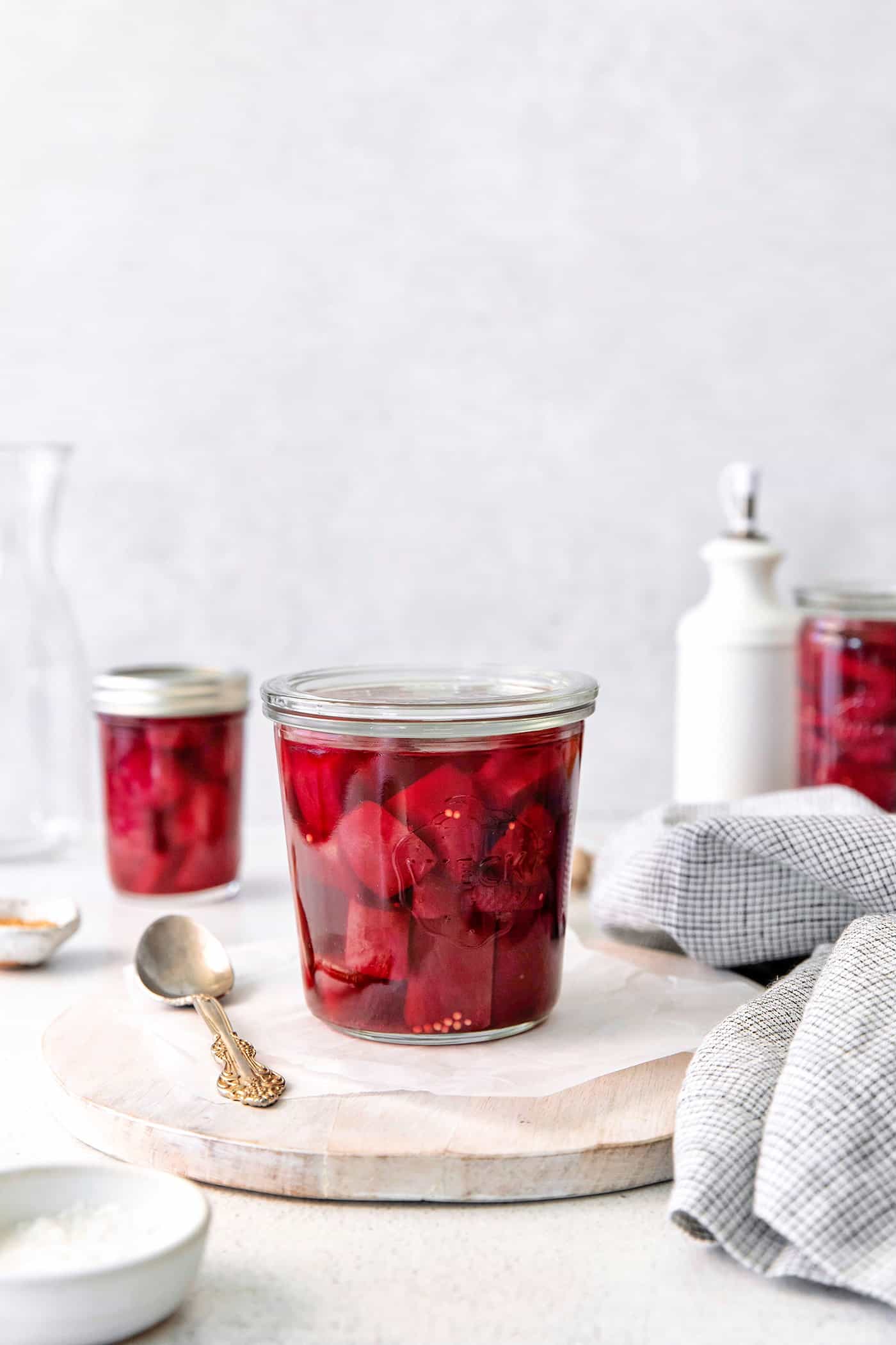 a jar of pickled beets on a cutting board