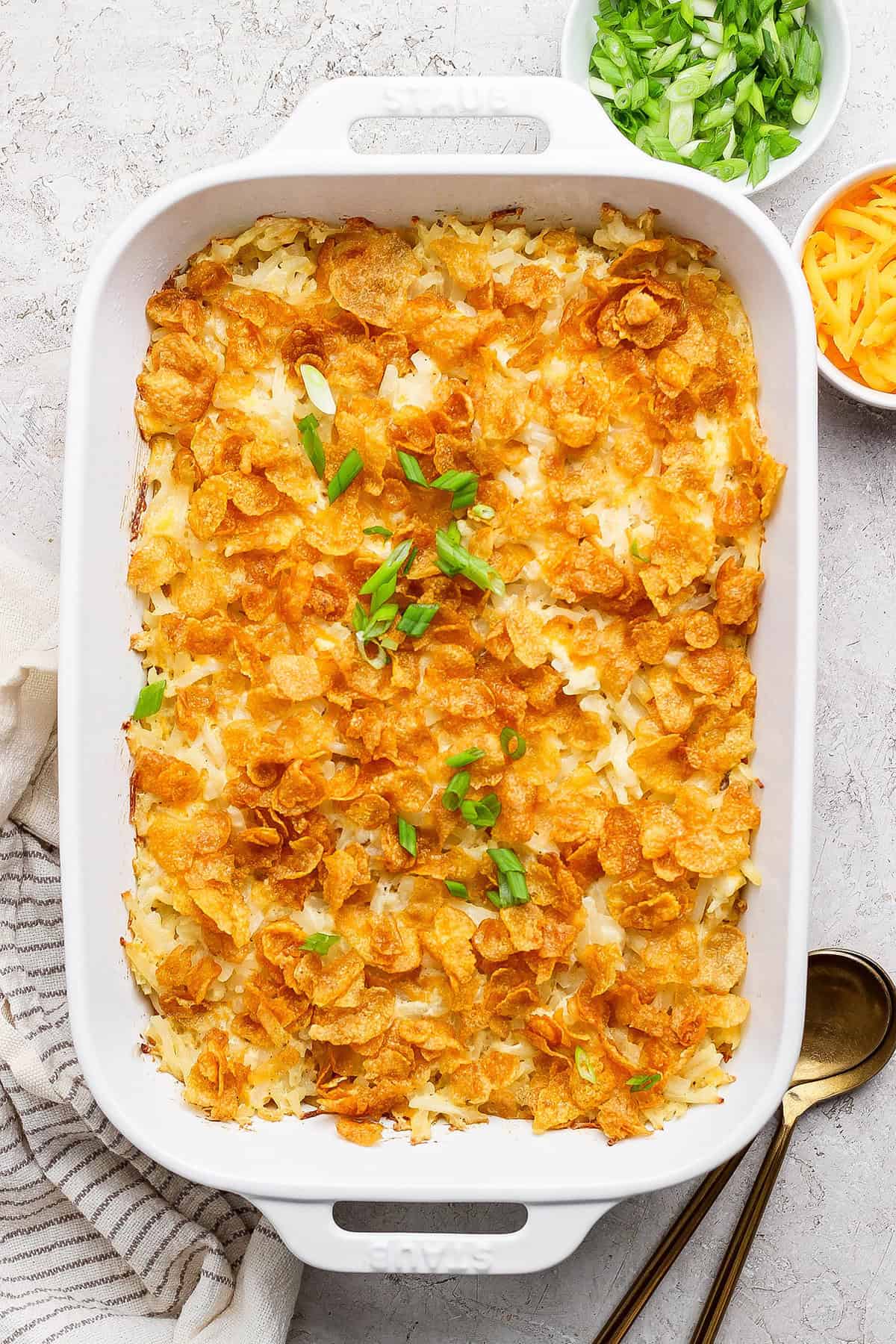 This cheesy hashbrown casserole recipe is an easy side dish that’s ready in under an hour. You'll love the crispy cornflake topping! Overhead view of cheesy hashbrown casserole in baking dish