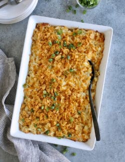 baked cheesy hashbrown casserole in a white baking dish