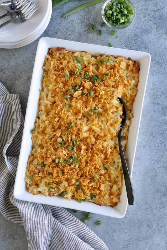 baked cheesy hashbrown casserole in a white baking dish