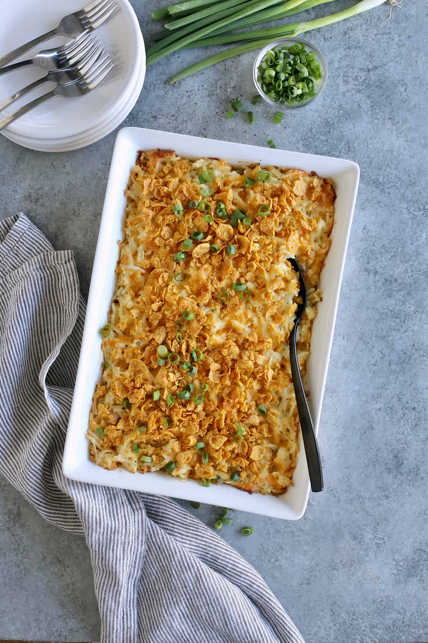 cheesy hashbrown casserole baked in a white rectangular dish