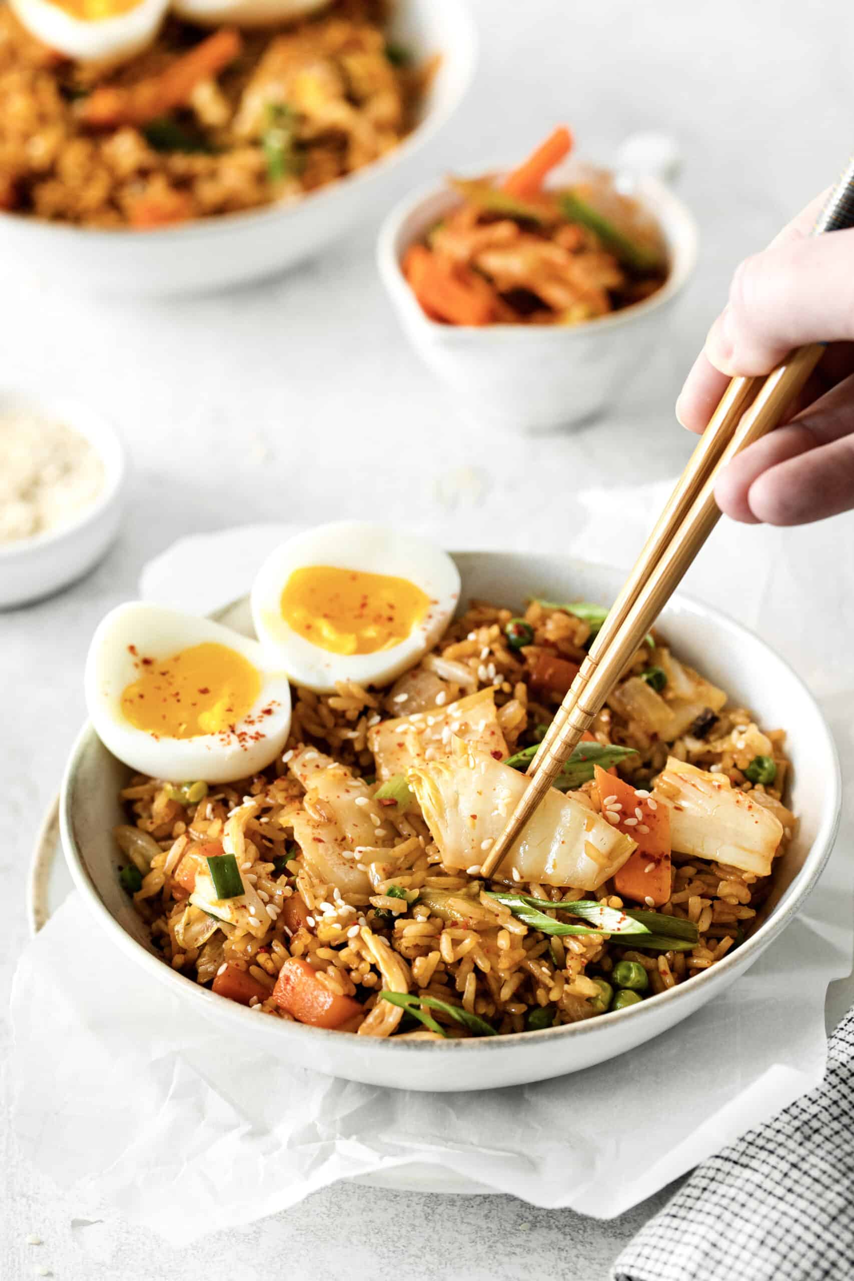 Chopsticks digging in to a bowl of kimchi fried rice