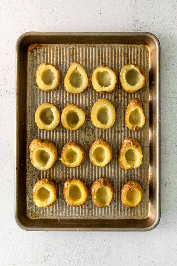 Mini potatoes with the centers removed on a baking sheet