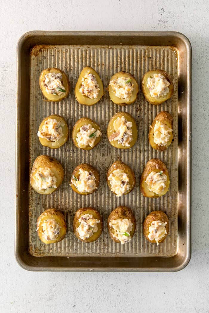 Loaded baked potatoes on a baking sheet