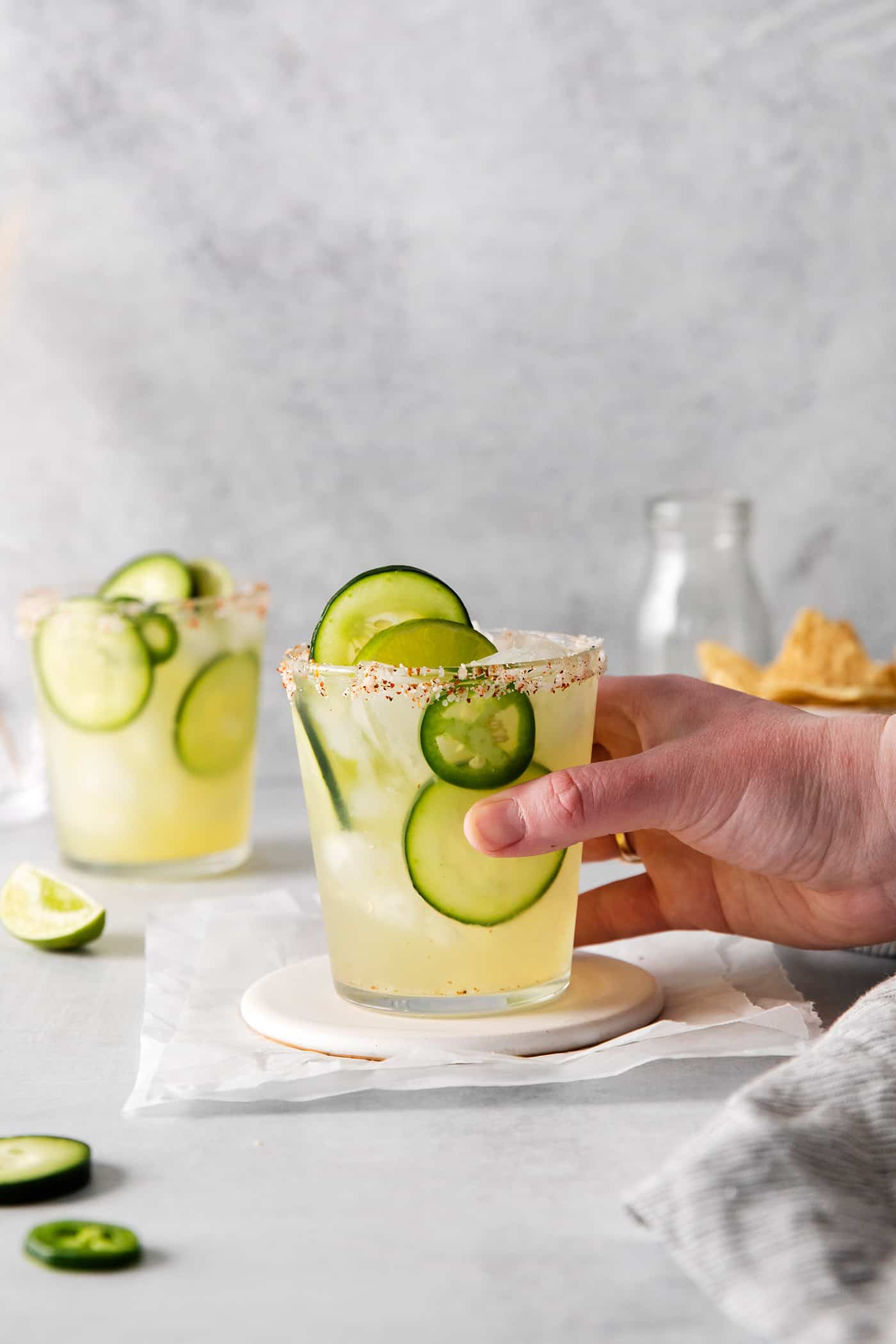 A hand holding a spicy cucumber margarita