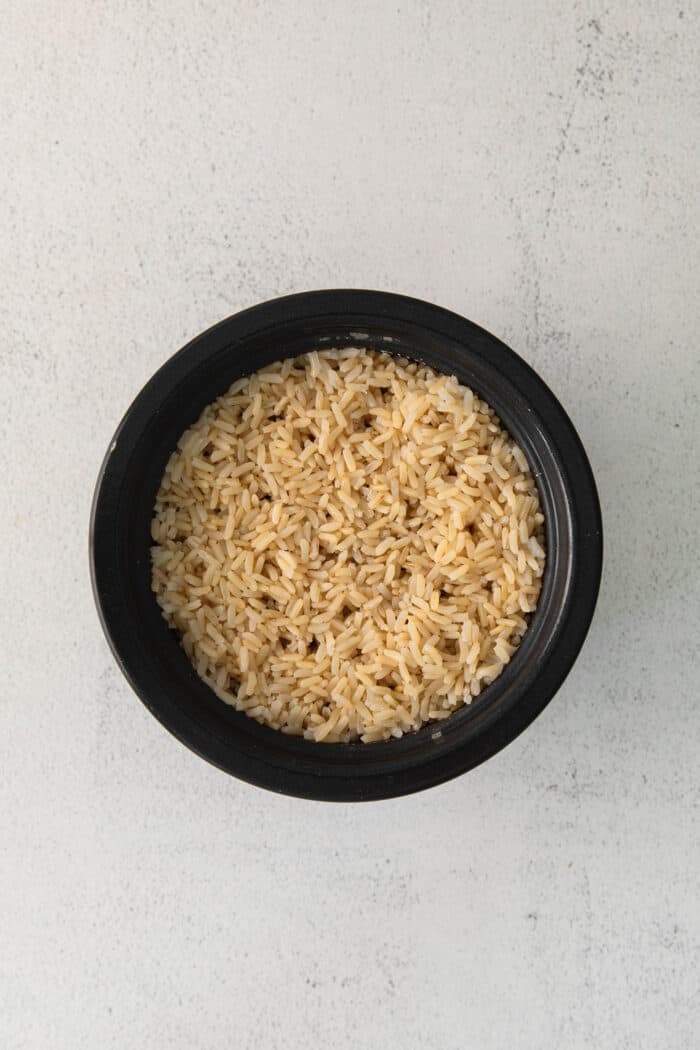 Cooked brown rice in a black rice cooker