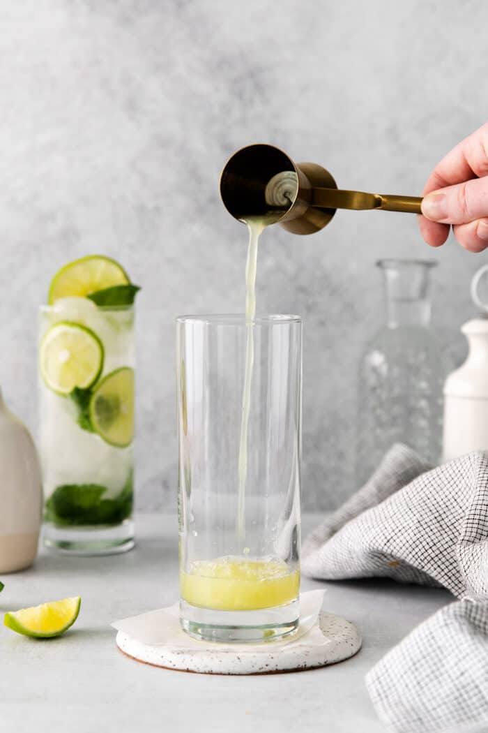 Lime juice being poured into a tall glass