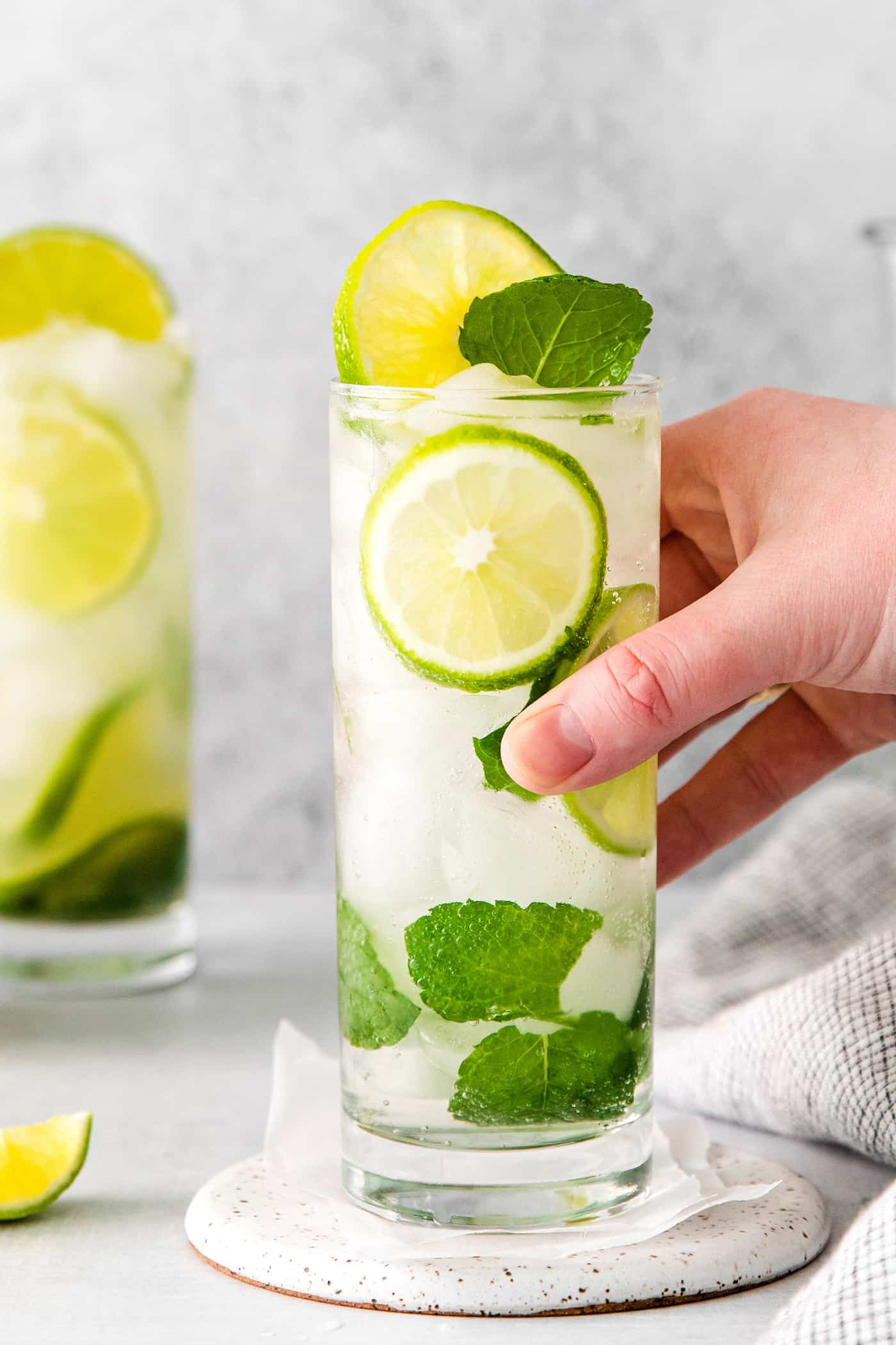 A hand grabbing a tequila mojito