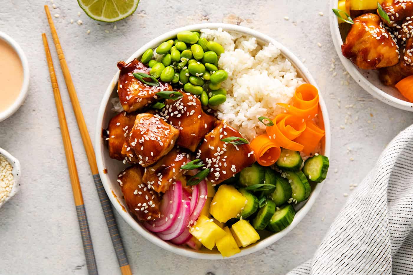 Overhead view of a teriyaki chicken poke bowl topped with fresh veggies