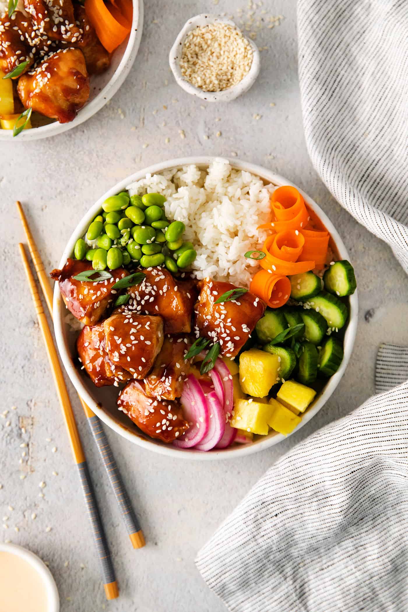 Overhead view of teriyaki chicken poke bowl topped with fresh veggies