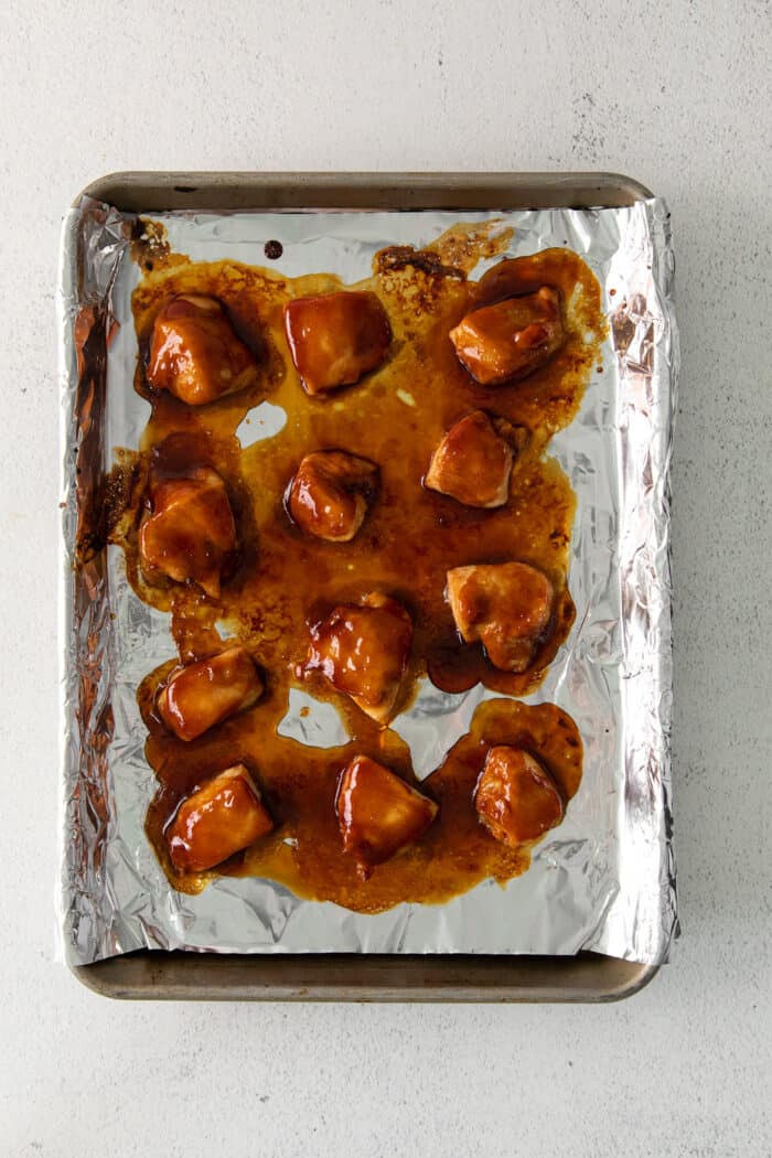 Cooked teriyaki chicken chunks on a baking sheet