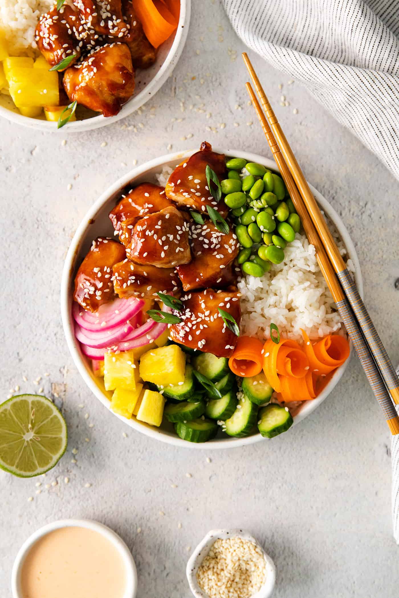 Overhead view of a teriyaki chicken rice bowl, with chopsticks resting on the bowl