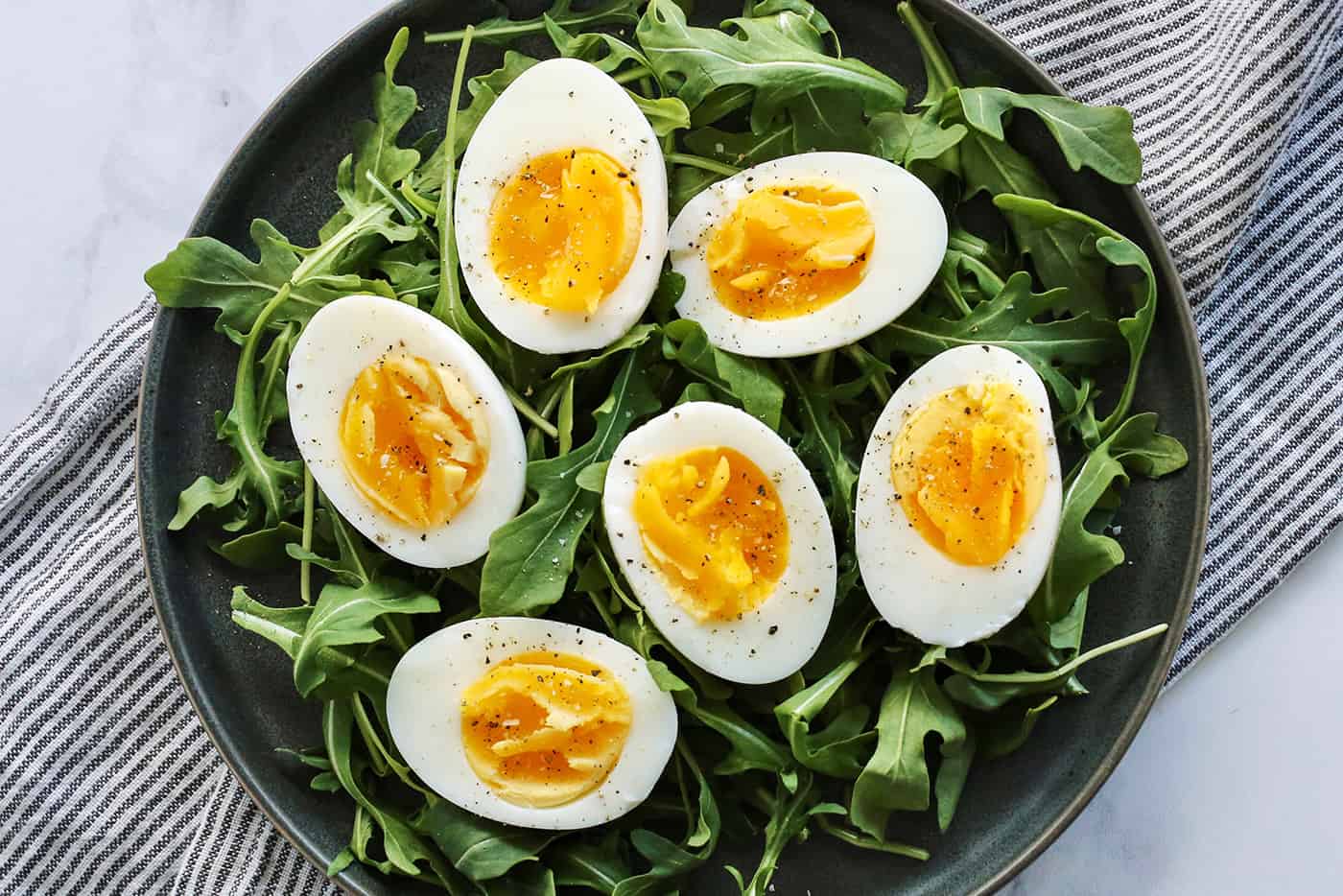 Air fryer hard boiled eggs on a bed of arugula