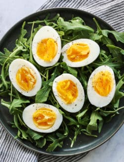Overhead view of air fryer hard boiled eggs on a bed of arugula