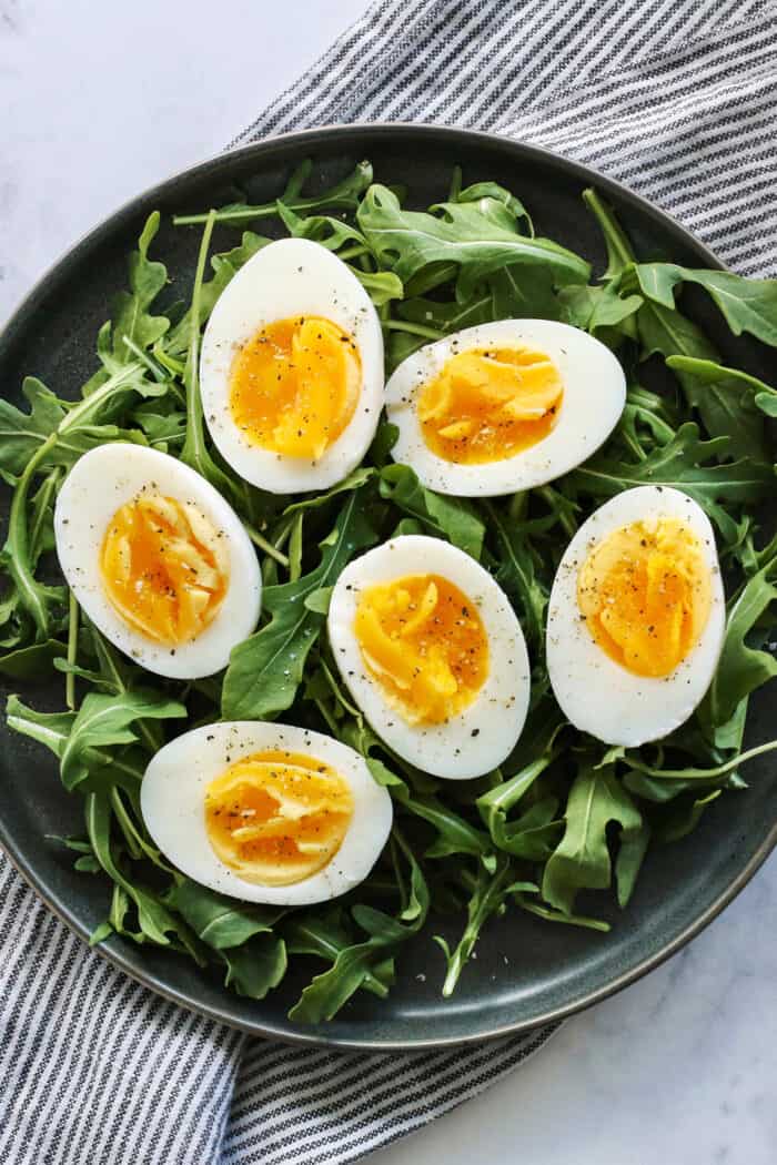 Overhead view of air fryer hard boiled eggs on a bed of arugula