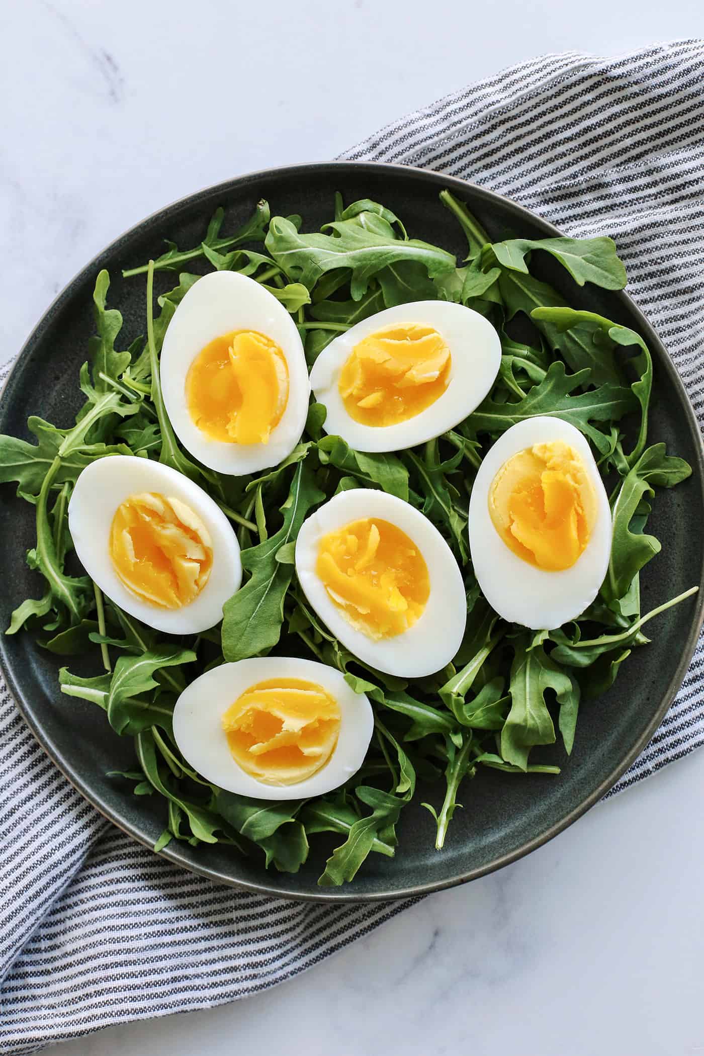 overhead view of hard boiled eggs on a bed of arugula