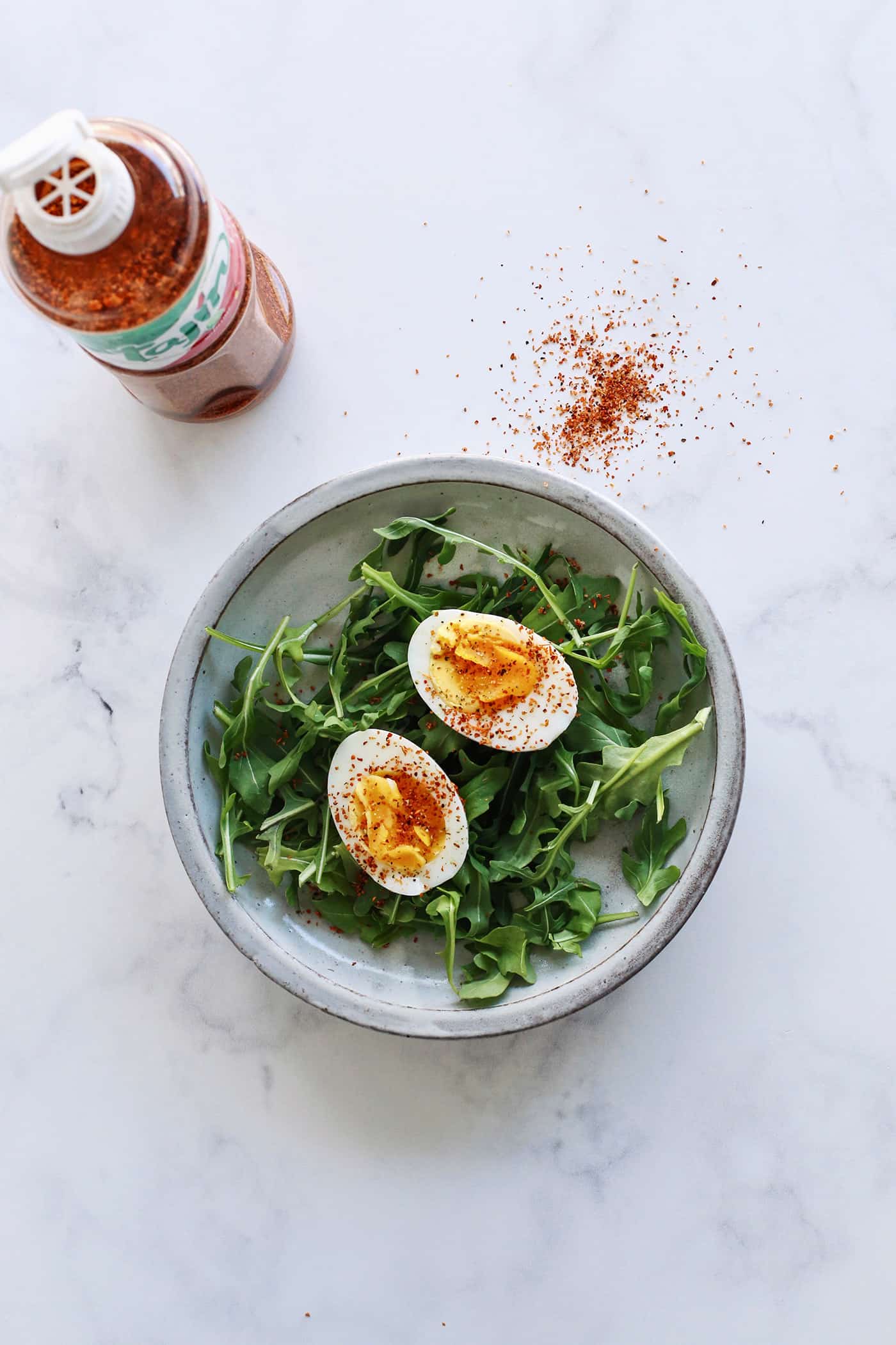 A hard boiled egg cut in half topped with Tajin