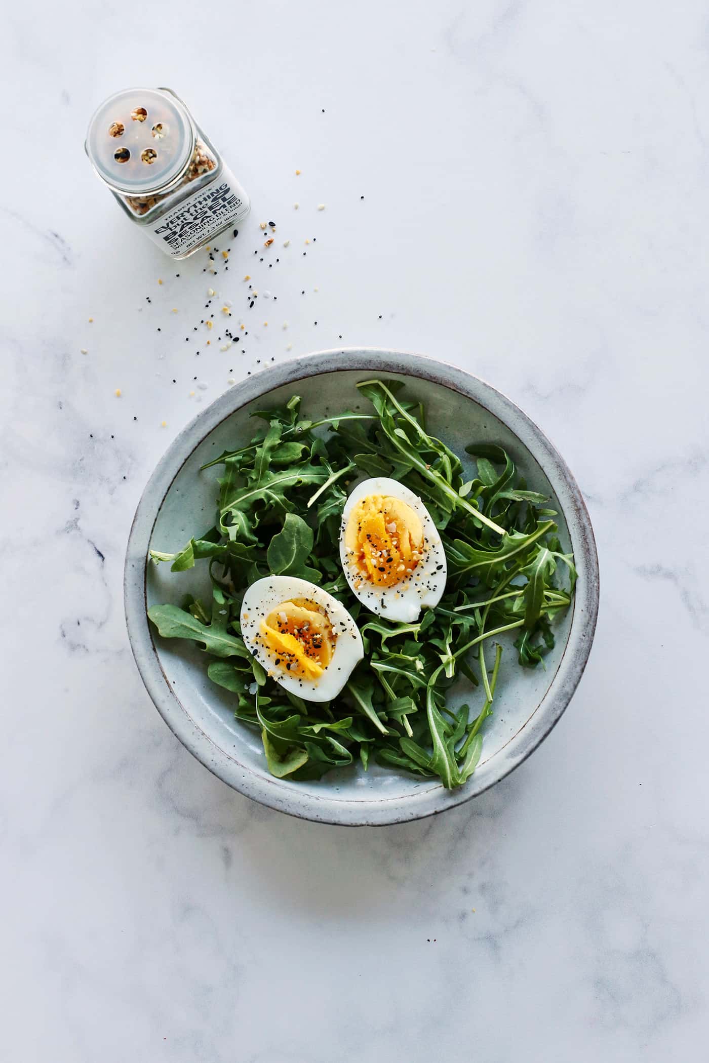 Two halves of an air fryer hard boiled egg on arugula