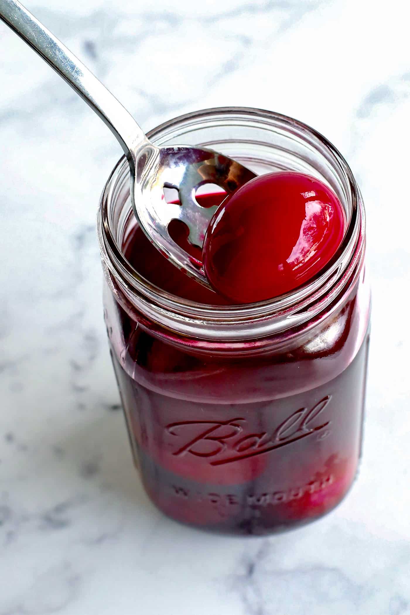 A spoon serving a beet pickled egg